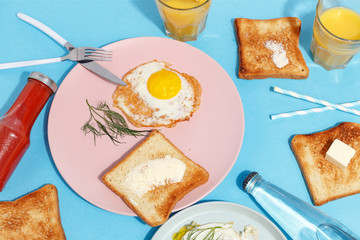 Scrambled eggs, buttered toasts and drinks on a blue table. Breakfast. Top view.