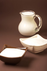 Homemade yogurt in ceramic square bowls, a jug brim full of yogurt behind the bowls. Healthy food from yogurt concept