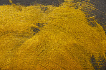 different brushstrokes of golden paint on grey background