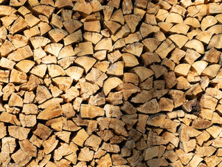 Background of dry chopped firewood logs in a pile.