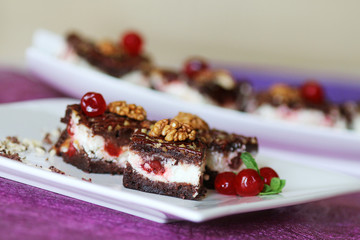 Milk mousse cake decorated with cherry and walnuts