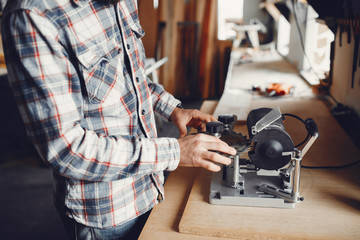 A man carves a tree. The carpenter works in a studio. An engineer provides a tree shape