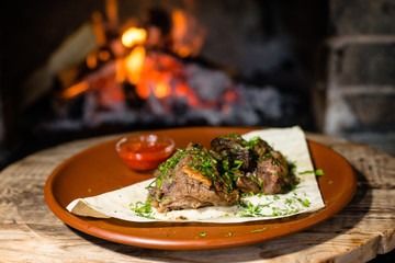 fried meat with sauce on fire background