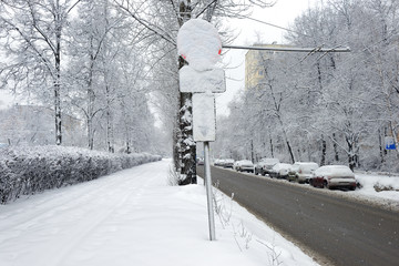 Road sign covered with snow after heavy snowfall