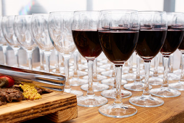 Many empty wine glasses and glasses with red wine