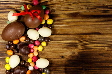 Obraz na płótnie Canvas Easter composition with chocolate eggs on wooden background