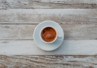 Turkish or Greek Hot Coffee on the white rustic wooden table with spilled coffee beans. This is traditional tasty refreshment greek or turkish coffee from greek or turkish cuisine culture