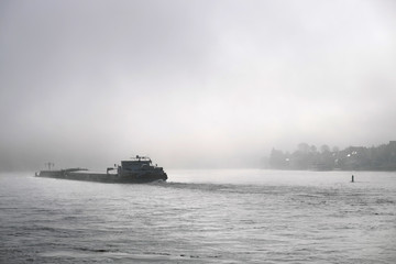 Frachtschiff auf dem Rhein im Nebel - Stockfoto