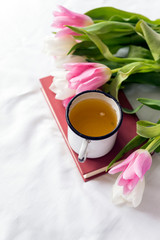 white and pink tulips, tea mug, book, white sheet, flowers,