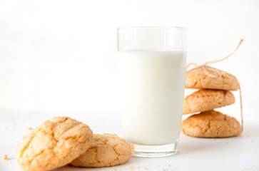 milk in a glass, some cookies on a white background
