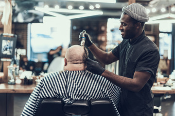 Attractive professional making hair cutting to his client