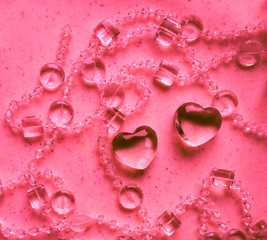 Transparent hearts and beads on marble in pink tone. Perfect Valentine's Day greeting card background.