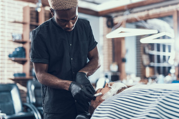 Handsome man shaving client in barber shop