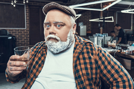 Handsome man with face in foam looking at camera 
