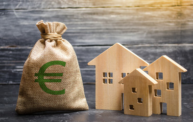 A bag with euro money and three houses. Affordable cheap loan, mortgage. Taxes, rental income. Building houses. Municipal budget of the community. Concept of real estate acquisition and investment. - obrazy, fototapety, plakaty
