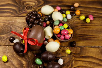 Easter composition with chocolate eggs on wooden background