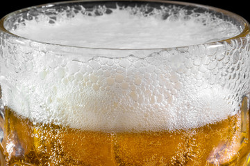 Glass of beer on dark background. Сlose-up of bubbles