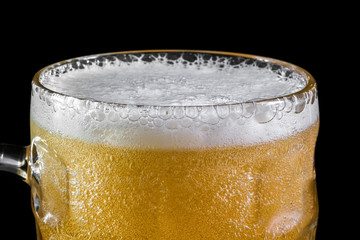 Mug of svezhy beer close up on a black background