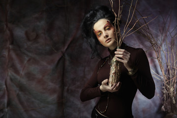 woman with bright make up with dry branches