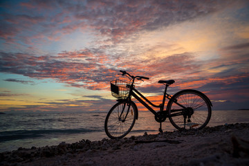 Sunset silhouette of vintage bicycle on the beach 