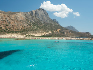 Fototapeta na wymiar Balos Lagoon Blue sea, hills and boat, transparent water as a swimming pool, Crete Island, Greece