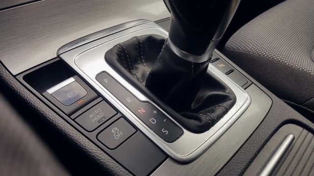 The man's hand in close-up switches the transmission of an automatic gearbox. Parking, drive, reverse.