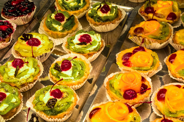 Naklejka premium Multi-colored, different and tasty cakes on a show-window in cafe. For every taste. Big assortimt sweets. Natural product.