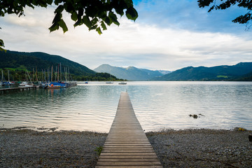 Picturesque view of wooden pier in the beach of Tegernsee lake near Gmund am Tegernsee in Germany