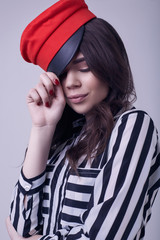 Fashion brunette woman wearing a striped blouse and red hat