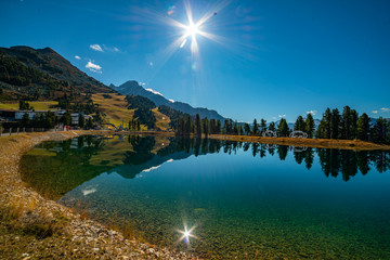 Obraz premium A mountain lake with a clear blue sky. Sun shining and perfect reflection.