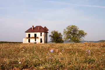 Old, abandoned, ruined house in the field