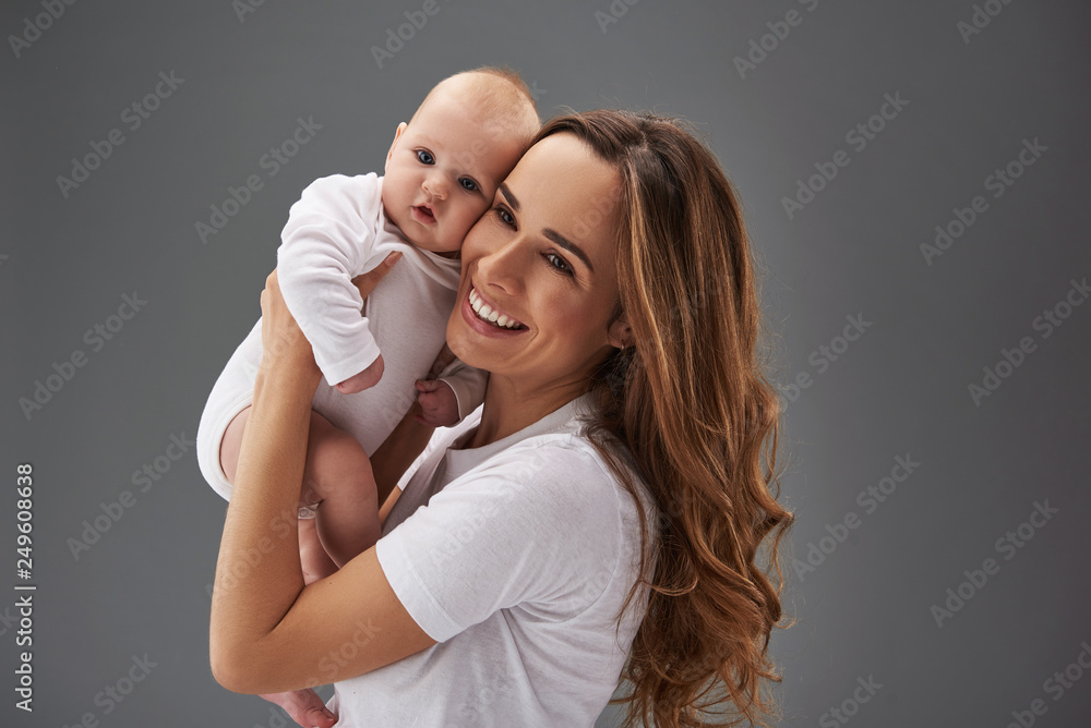 Wall mural pretty mommy with small baby on her hands