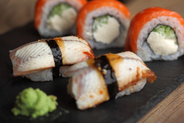 Sashimi sushi set with Philadelphia roll sushi on black slate plate background.Nigiri.Closeup.