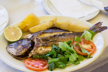 Grilled sea bream with poatatoes, tomatoes and lemon
