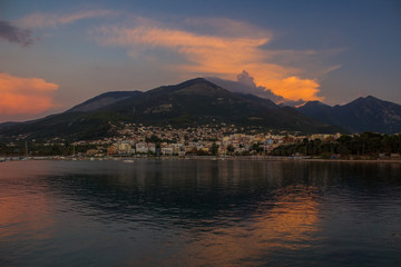 South Europe landscape soft focus view of small city near sea on lonely mountain background in evening twilight time after sunset 
