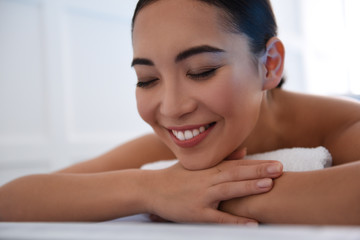 Obraz na płótnie Canvas Happy asian lady laying on massage table