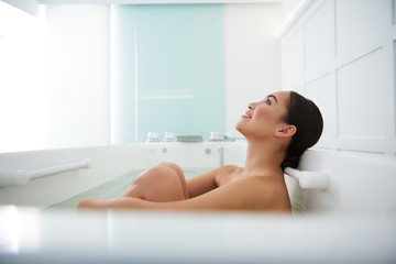 Obraz premium Calm smiling asian lady enjoying spa bath