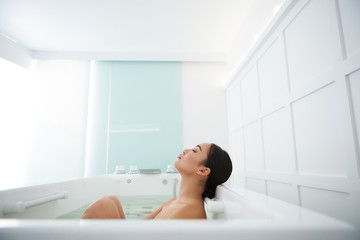 Calm relaxed asian lady enjoying spa bath