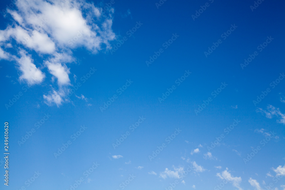 Wall mural clean bright blue sky with fluffy clouds