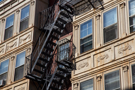 Fire escape stairs-downtown back alley architecture-steel and yellow brick background - Powered by Adobe