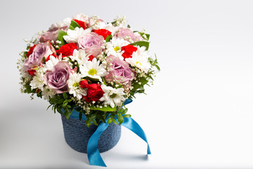 Beautiful designer bouquet of flowers in a beautiful cramped blue bucket.Isolated on a white background
