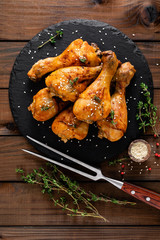 Grilled chicken legs on wooden background. Top view