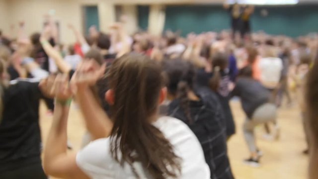 People on the open lesson indoors. People learn dance move..