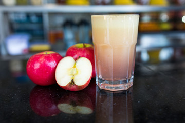 A glass of Apple juice and apple slices.
