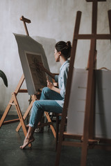 Full length of female artist drawing in art studio