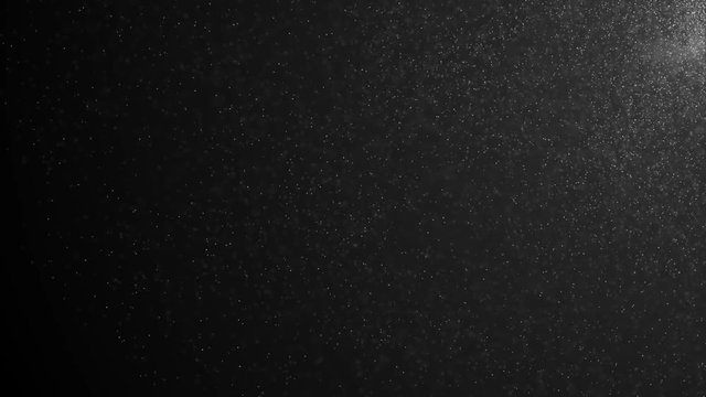 Floating particles of organic dust, iridescent on a black background. Particles rotating randomly, as if they were being blown away. Particles moving rapidly in space, each particle independently.