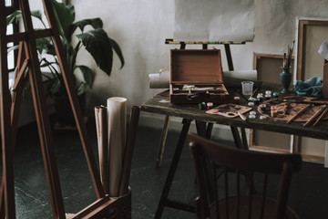 Table with artistic tools and easel on the left side