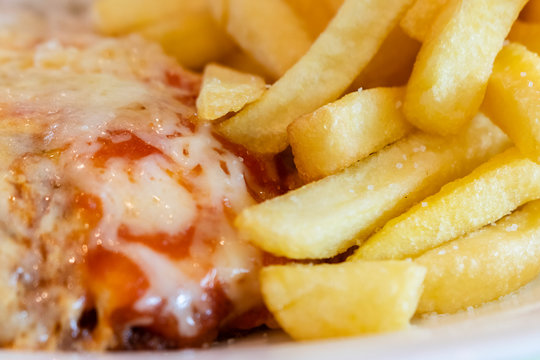 close-up on meal on plate, parmegiana chicken, potato chips