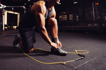 Man stretching up and getting ready to powerful workout on jump rope in boxing sport gym