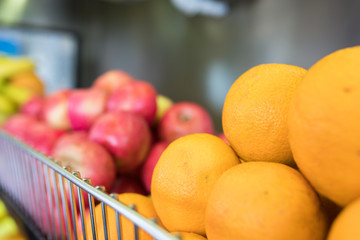 Fresh, natural and healthy organic orange and apple fruits on shell in supermarket. Healthy food concept. Farmers market